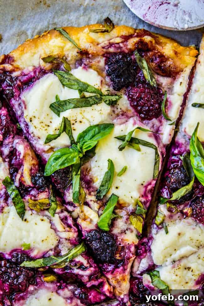 Blackberry Ricotta Pizza from The Food Charlatan. A simple ricotta pizza for lazy summer nights! It is mostly cheese and blackberries, which is a fabulous combo. Add some basil on top for some extra flavor! #pizza #ricotta #basil #blackberries #gourmet Delicious Blackberry Ricotta Pizza garnished with fresh basil, perfect for summer.