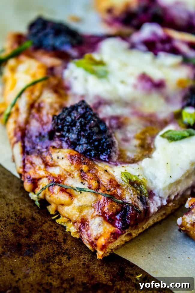 Blackberry Ricotta Pizza from The Food Charlatan. A simple ricotta pizza for lazy summer nights! It is mostly cheese and blackberries, which is a fabulous combo. Add some basil on top for some extra flavor! #pizza #ricotta #basil #blackberries #gourmet Close-up of fresh basil on a baked Blackberry Ricotta Pizza, highlighting the green herbs.