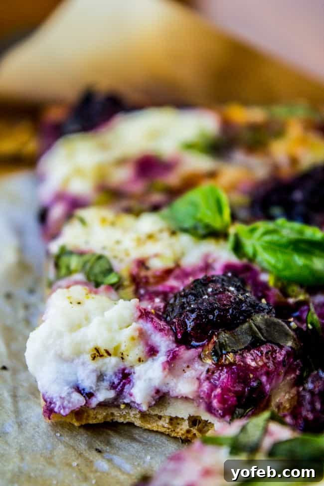 Blackberry Ricotta Pizza from The Food Charlatan. A simple ricotta pizza for lazy summer nights! It is mostly cheese and blackberries, which is a fabulous combo. Add some basil on top for some extra flavor! #pizza #ricotta #basil #blackberries #gourmet Blackberries scattered on a pizza before baking, showcasing the fresh fruit.