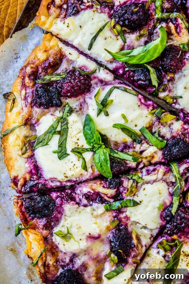 Blackberry Ricotta Pizza from The Food Charlatan. A simple ricotta pizza for lazy summer nights! It is mostly cheese and blackberries, which is a fabulous combo. Add some basil on top for some extra flavor! #pizza #ricotta #basil #blackberries #gourmet Assembling a Blackberry Ricotta Pizza with smashed blackberries and cheeses.