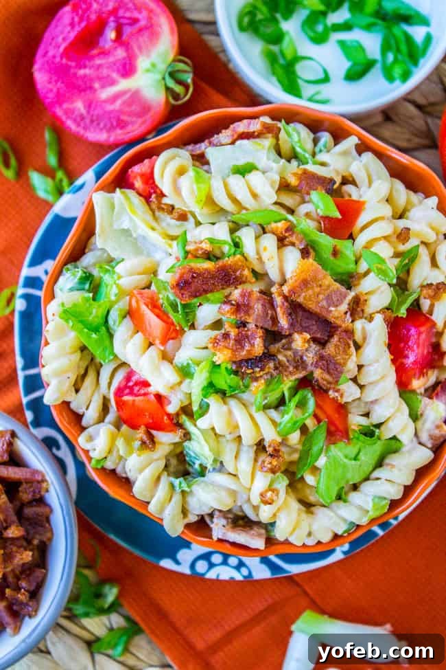Creamy BLT Pasta Salad 8 A large, inviting bowl of BLT pasta salad on a rustic wooden surface.