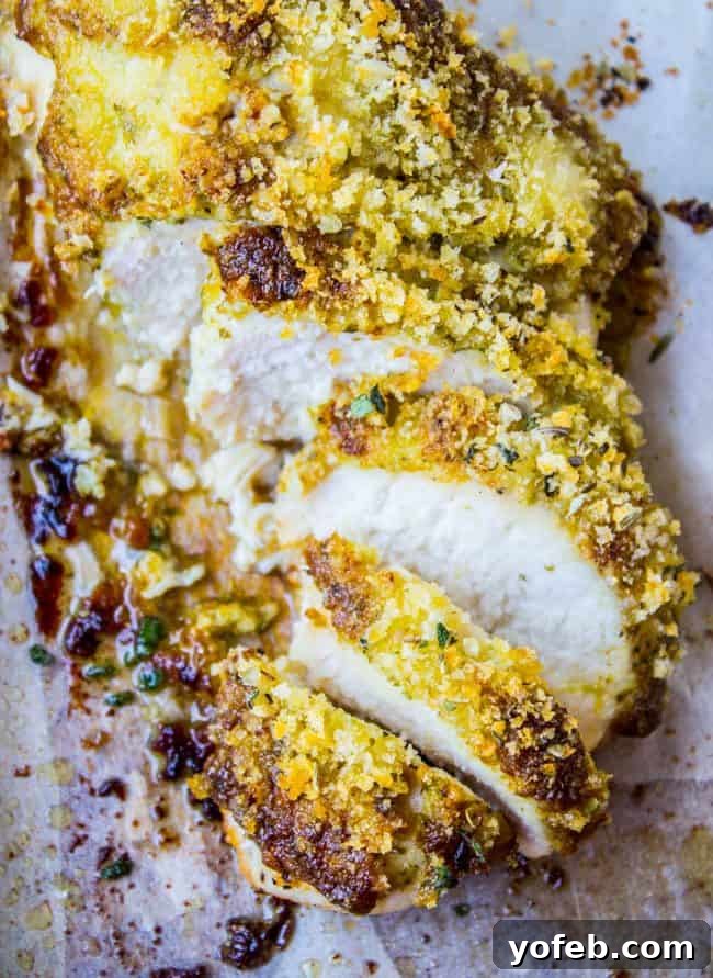 Zesty Basil Pesto Chicken 4 Perfectly baked, sliced breaded chicken on parchment paper, ready to be served.