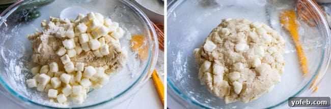Small cubes of sugared cream cheese are gently folded into the scone dough in a large mixing bowl, ready for baking.