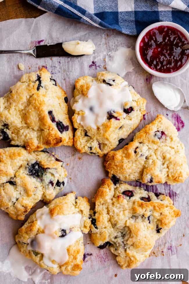 A beautiful circular arrangement of glazed and plain scones, with rich butter and an assortment of jams presented alongside, inviting indulgence.