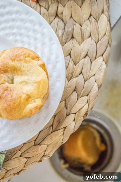 Quick Crescent Chicken Pot Pie Bites 3 Mini chicken pot pie fallen into sink drain with a mini chicken pot pie on a white plate above it.