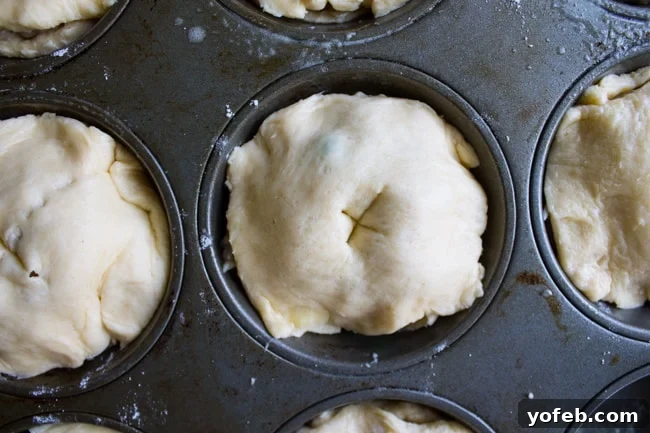 Quick Crescent Chicken Pot Pie Bites 8 Uncooked mini chicken pot pies in a muffin tin with slits for venting steam.