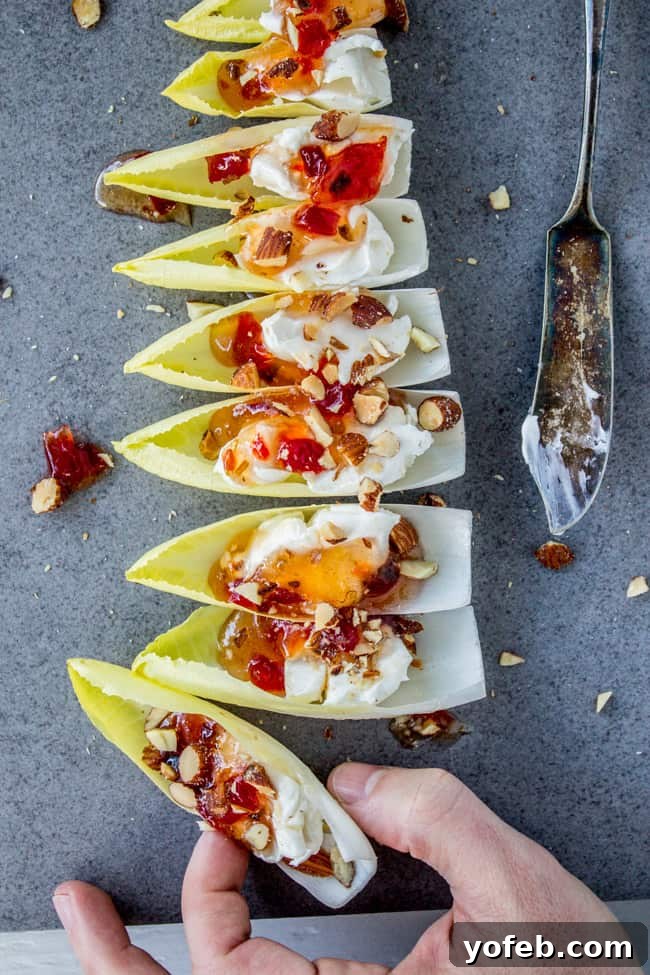 Smoky Almond & Cream Cheese Endive Boats 4 Close-up of Smokey Almond Cream Cheese Endive Bites, showcasing the creamy filling and crunchy topping.