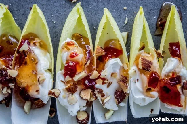 Smoky Almond & Cream Cheese Endive Boats 7 Assortment of Smokey Almond Cream Cheese Endive Bites arranged on a platter, ready to be served.