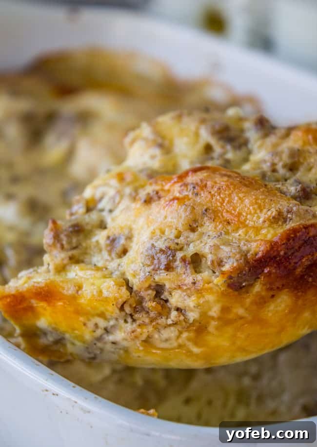 Overnight Biscuits and Gravy Casserole: a hearty, family-favorite breakfast bake with homemade sausage gravy. Close-up of the golden-brown top of a freshly baked biscuit and gravy casserole, rich with cheese and sausage.