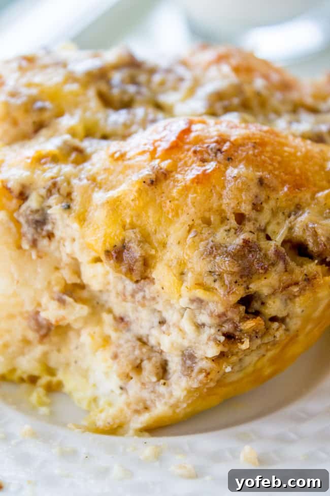 Perfectly baked Overnight Biscuits and Gravy Casserole, a delightful and filling breakfast choice. A generous serving of Sausage Gravy Breakfast Casserole on a white plate, showing the layers of biscuit, egg, cheese, and gravy.
