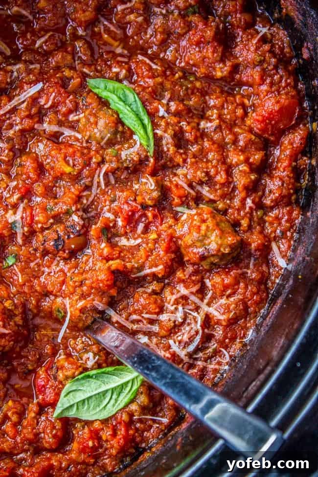 Effortless Slow Cooker Pasta Sauce 5 spaghetti sauce in the crockpot with fresh basil and shredded parmesan.