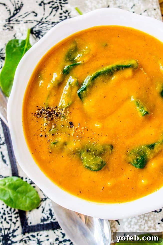 Creamy Vegan Cauliflower Soup 2 creamy vegan cauliflower soup with freshly ground pepper and spinach in a white bowl.