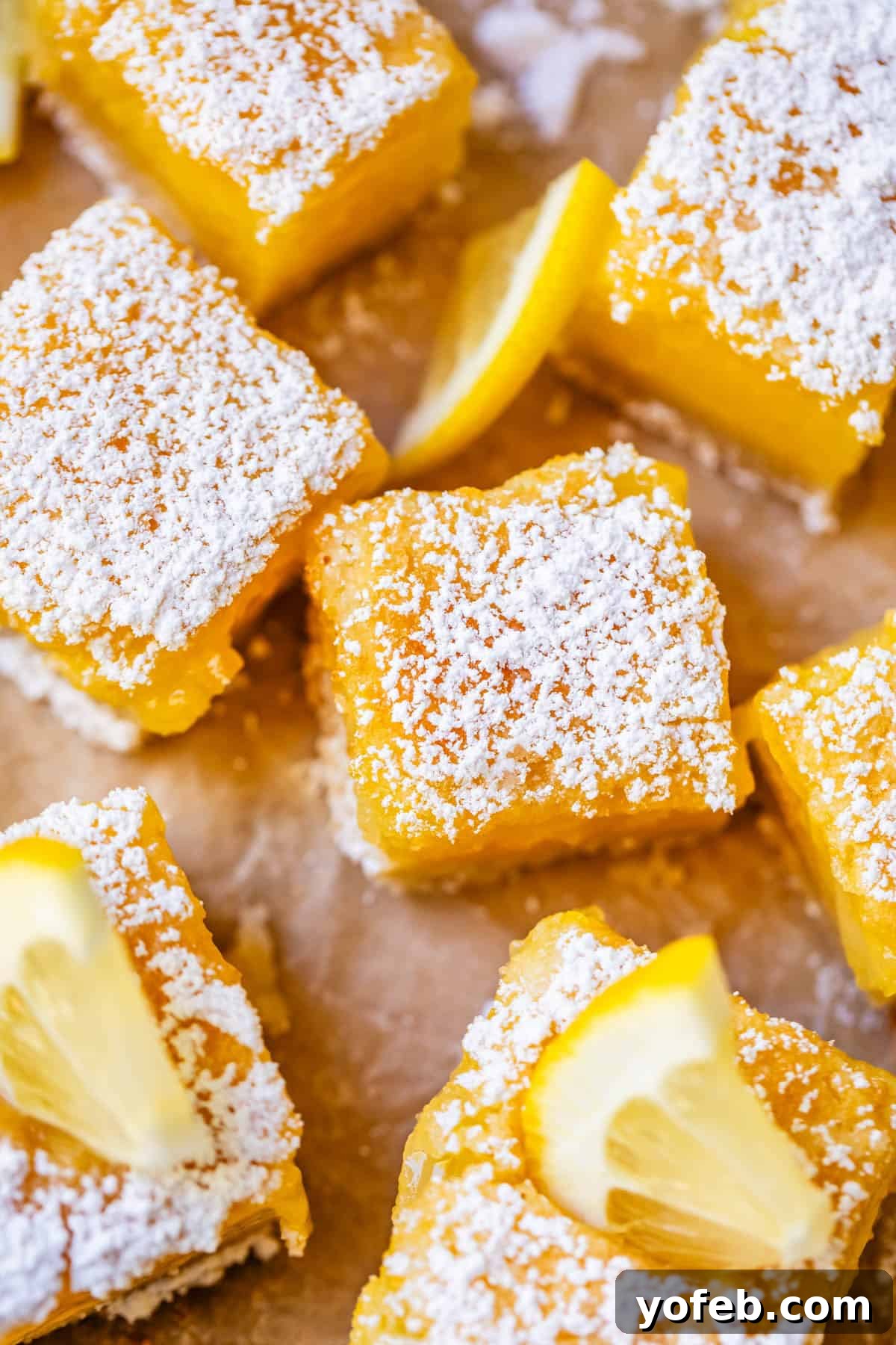 Seriously Zesty Lemon Bars My Absolute Best 5 close up of a few lemon bars cut into squares with powdered sugar and lemon.
