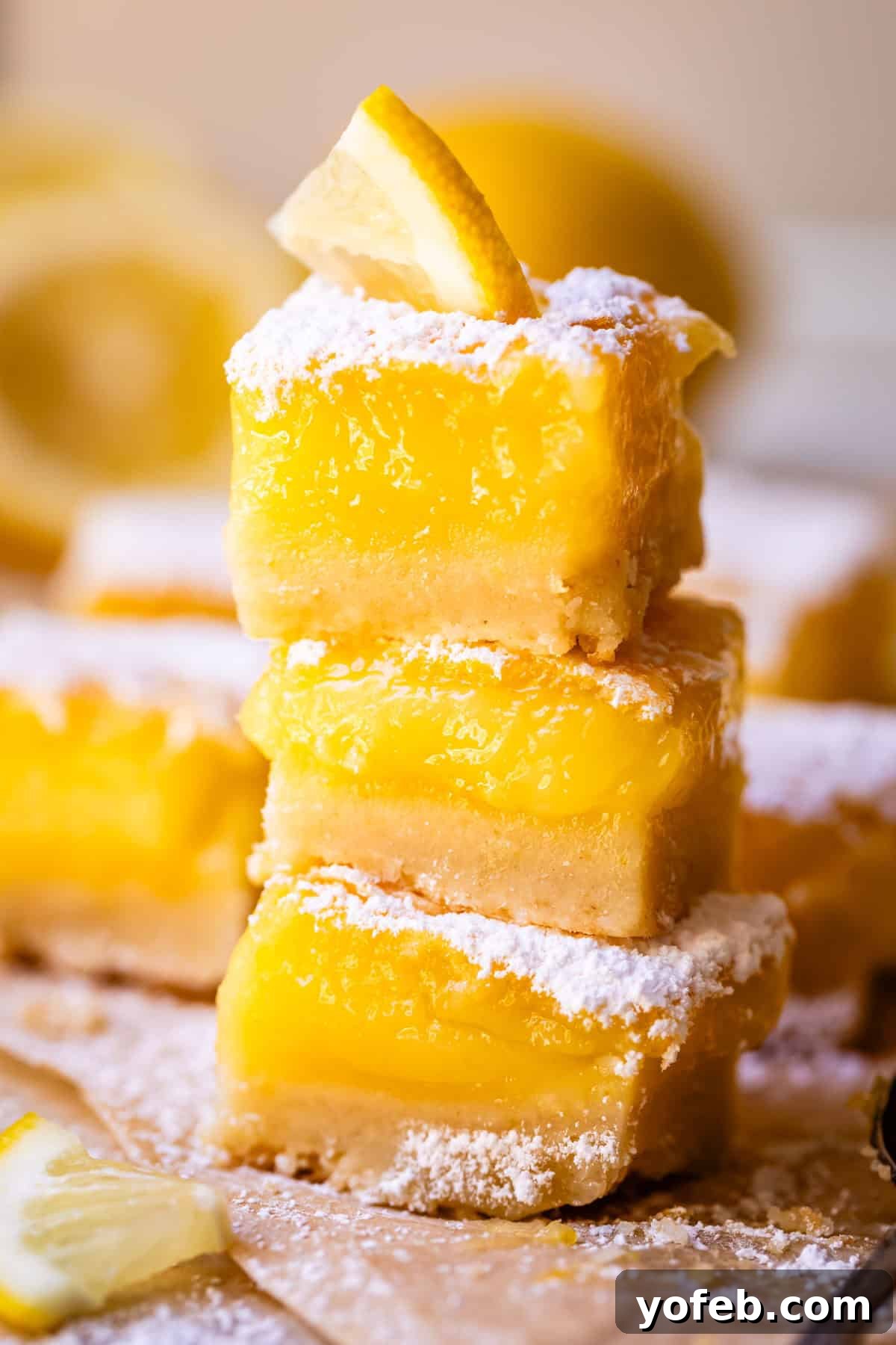 Seriously Zesty Lemon Bars My Absolute Best 7 stack of three lemon squares with shortbread crust, lemon filling, and powdered sugar layers.