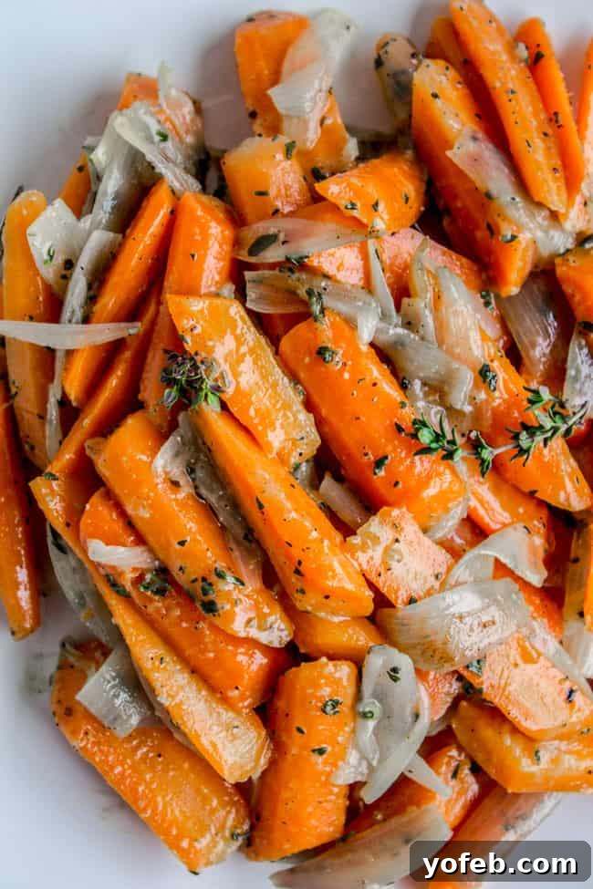 Thyme-Infused Sautéed Carrots and Shallots 3 Close-up of beautifully plated sautéed carrots and shallots garnished with fresh thyme leaves.