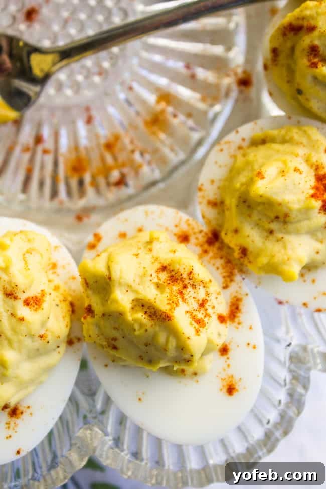 Timeless Deviled Eggs 2 A platter of classic deviled eggs generously sprinkled with vibrant paprika, ready to serve.