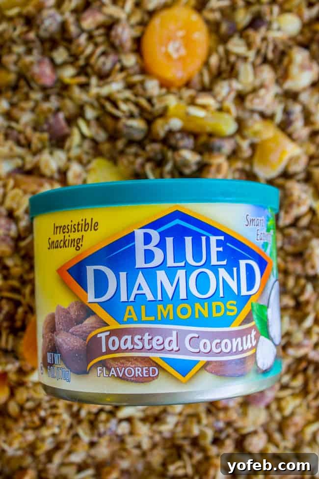 Sunshine Mango Coconut Granola 6 A hand holding a can of Blue Diamond Toasted Coconut Almonds, highlighting the key ingredient