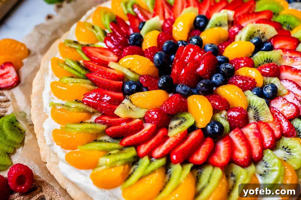 Pillowy Sugar Cookie Fruit Pizza Delight 22 A complete, perfectly glazed circular fruit pizza featuring a soft cookie crust, creamy frosting, and an abundant display of colorful fresh fruit.