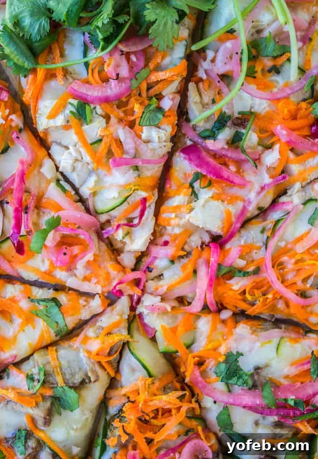 Tangy Thai Zucchini Pizza with Pickled Red Onions 9 Close-up of a perfectly sliced Thai chicken pizza, revealing layers of melted cheese, chicken, and tangy pickled red onions