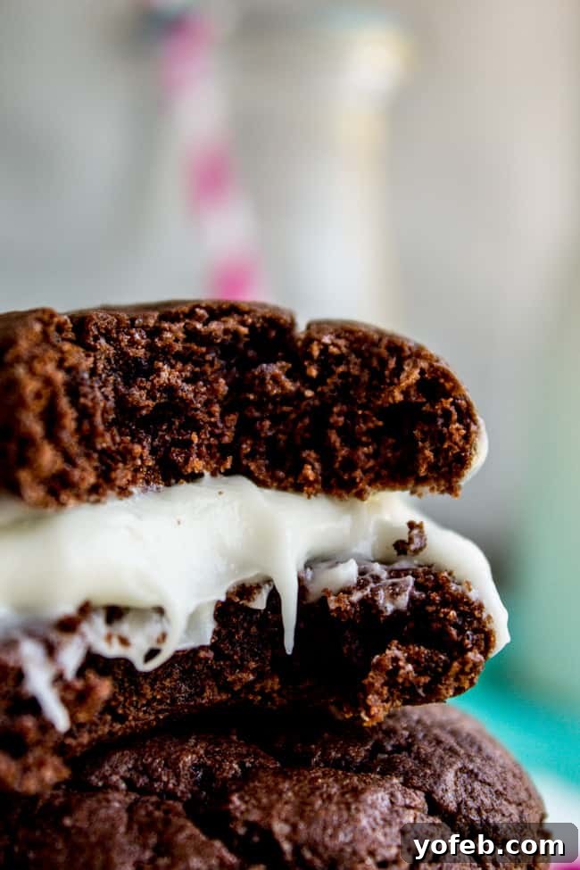 Homemade Cake Mix Oreos with Cream Cheese Filling 7 A hand reaching for a freshly made Homemade Oreo cookie with cream cheese frosting