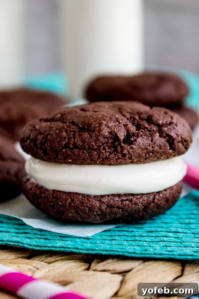 Homemade Cake Mix Oreos with Cream Cheese Filling 10 A stack of three Homemade Oreos on a wooden surface, showcasing the soft cookies and generous frosting