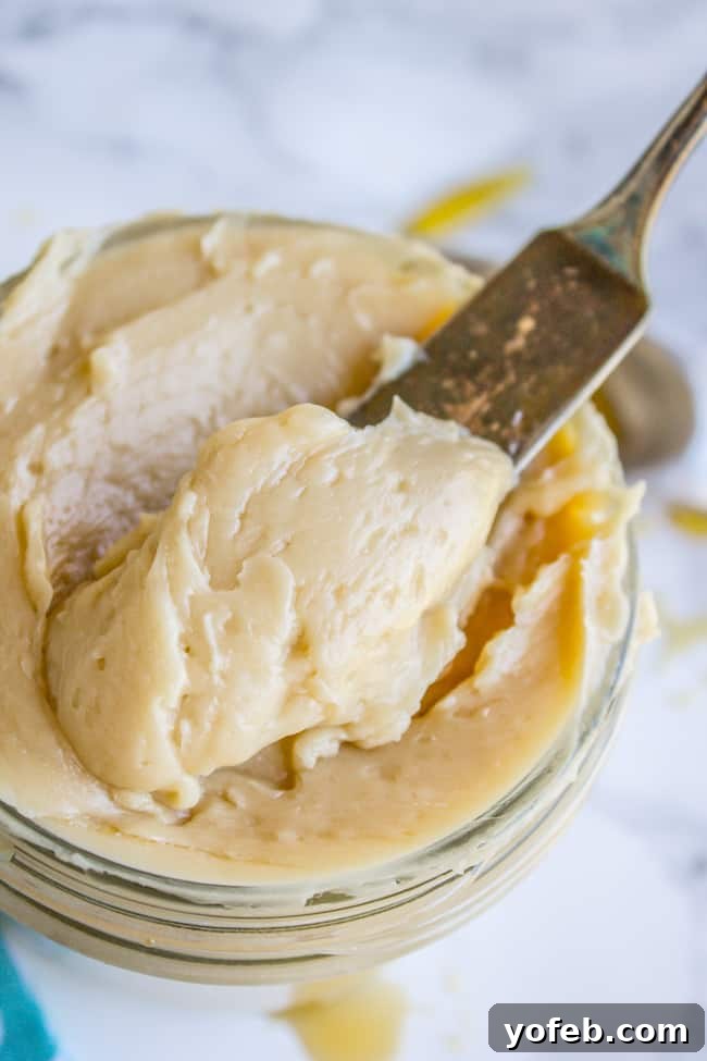 Quick Whipped Maple Butter 4 A knife preparing to spread maple butter from a glass jar, showcasing its creamy texture.