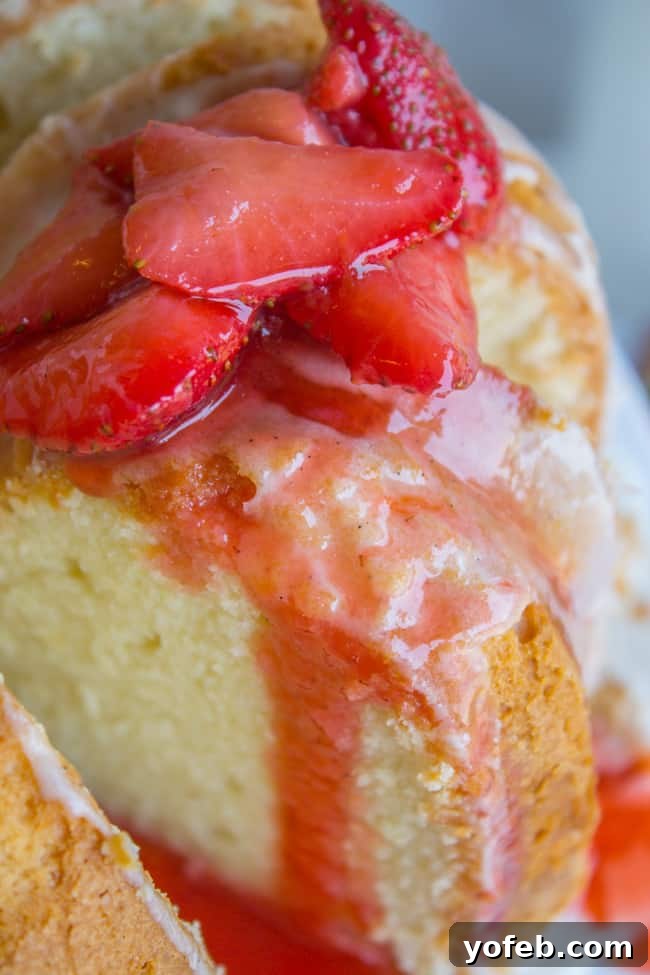The Ultimate Cream Cheese Pound Cake 2 A perfectly baked cream cheese pound cake with a luscious vanilla glaze, adorned with fresh strawberries, ready to be served.