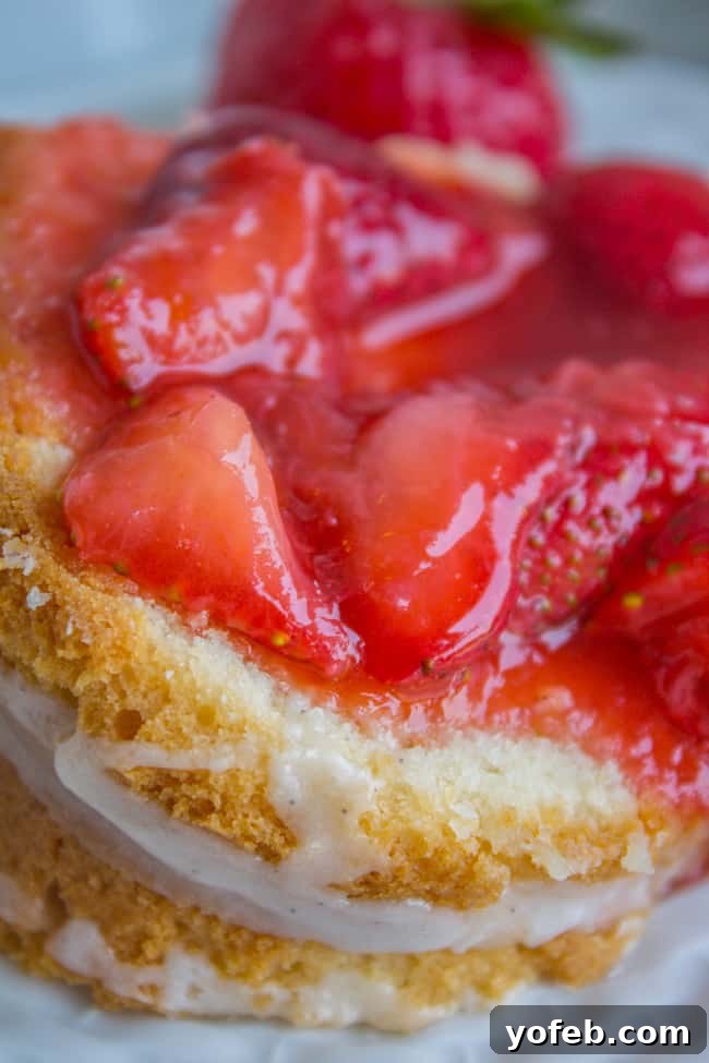 The Ultimate Cream Cheese Pound Cake 5 A delectable slice of cream cheese pound cake, topped with vanilla glaze and fresh strawberry slices, demonstrating its inviting texture.