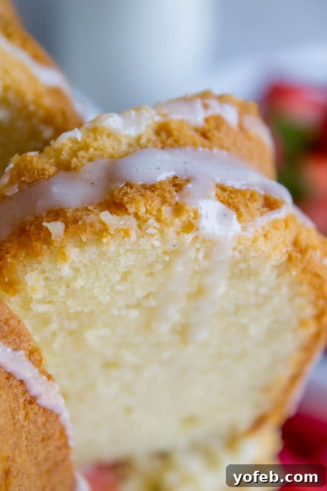 The Ultimate Cream Cheese Pound Cake 9 A close-up of the cream cheese pound cake, showcasing its golden-brown crust and moist interior, with glistening vanilla glaze.