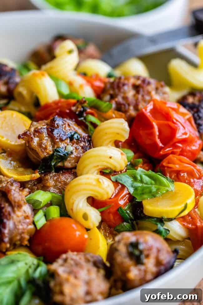 Italian Sausage Pasta Ready to Serve A large, steaming bowl of Italian Sausage Pasta with Cherry Tomatoes, garnished with fresh basil, ready to be served for a family dinner.