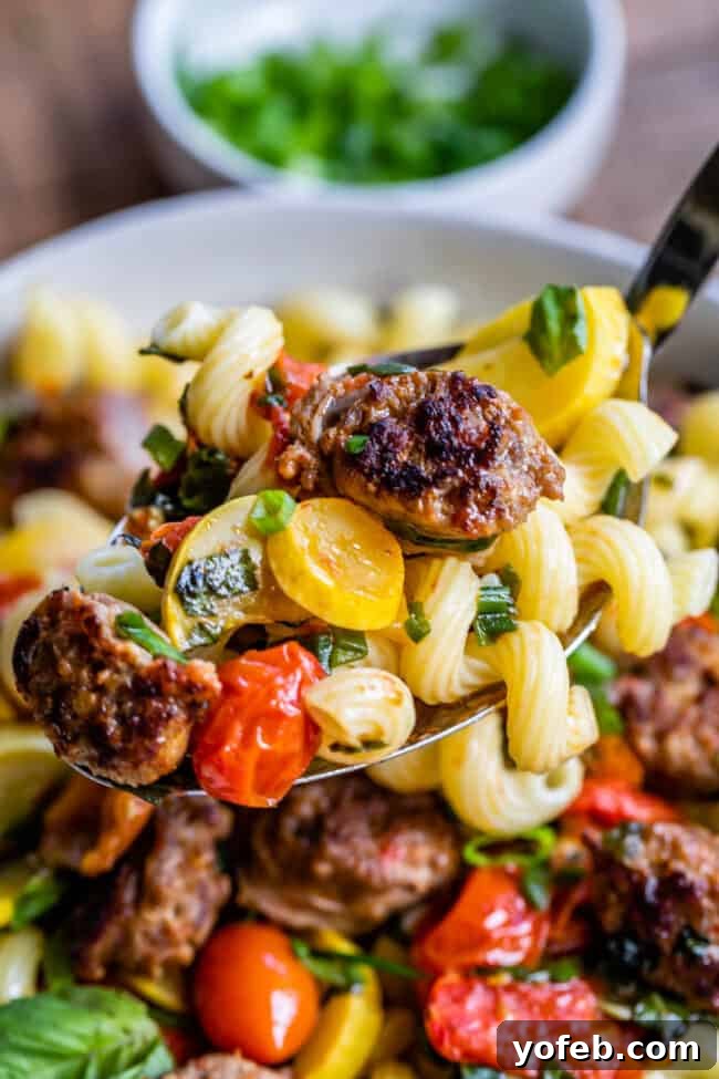 Italian Sausage Penne Pasta Ingredients A vibrant mix of fresh ingredients for Italian sausage pasta, including halved cherry tomatoes, sliced yellow squash, fresh basil, and green onions, waiting to be cooked.