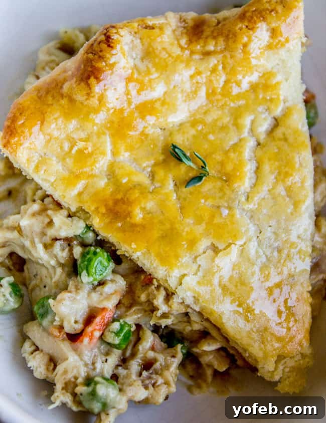 Comforting Classic Chicken Pot Pie 3 A generous slice of chicken pot pie with a beautifully flaky, golden-brown crust.