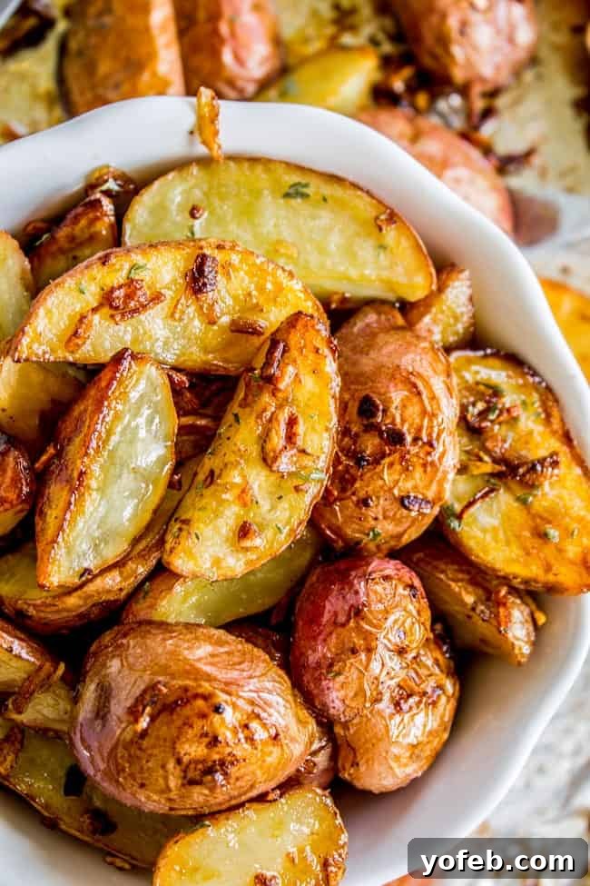 Serving of Roasted Potatoes with Onions A serving bowl filled with a generous portion of roasted potatoes and onions, showcasing their golden-brown exterior and tender interior.