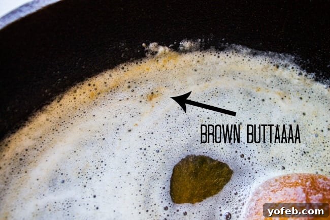 The Ultimate Brown Butter Chocolate Chip Cookies 9 Golden brown butter simmering in a cast iron pan, showing the nutty specks at the bottom.