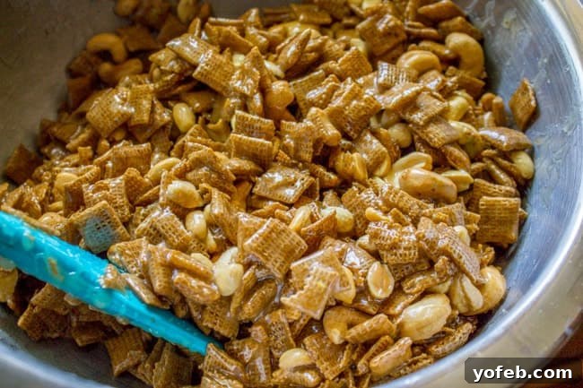 Sticky Sweet-and-Salty Chex Mix (Christmas Crack Recipe) from The Food Charlatan. I've got your yummy Christmas Crack recipe right here! This Sticky Sweet and Salty Chex Mix gets its name for good reason! Once you start you just can't stop. A simple syrup (with LOTS of butter) gets drizzled over corn Chex and studded with nuts and M&Ms. It is salty-sweet perfection! #christmascrack #christmas #chexmix #chex #m&m #sweetandsalty #dessert #yummy #syrup #candy Holiday Chex mix, freshly coated in the glistening caramel syrup, ready for the final touches.