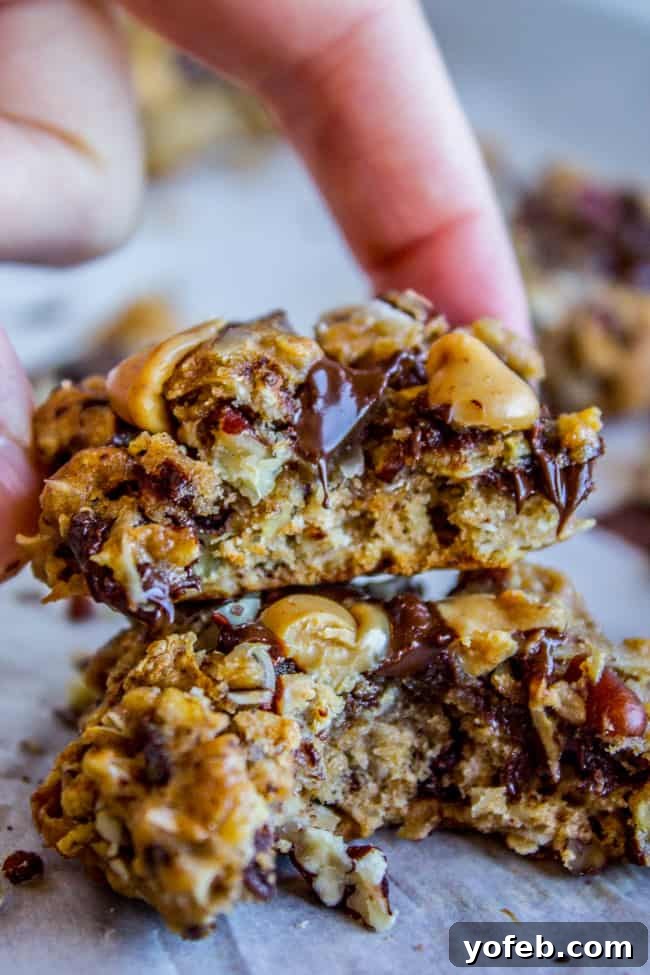 Skinny Texas Cowboy Cookies by The Food Charlatan. These low calorie cookies have NO sugar, NO white flour, and only 2 tablespoons of butter in the whole batch! What they do have are a ton of mix-ins. Oatmeal, coconut, bran flakes, pecans to name a few. They taste like a Texas Cowboy Cookie, but way better for you! (Which means I can eat half a batch...right?) #skinny #texascowboycookies #healthy #cookies #lowcalorie #nosugar #noflour #lowcarb #easy #recipes Close-up of a stack of Low Calorie Cookies, highlighting their texture and mix-ins.