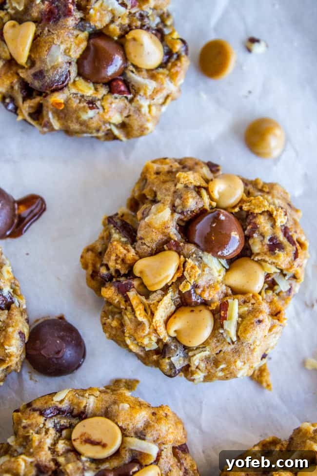 Skinny Texas Cowboy Cookies by The Food Charlatan. These low calorie cookies have NO sugar, NO white flour, and only 2 tablespoons of butter in the whole batch! What they do have are a ton of mix-ins. Oatmeal, coconut, bran flakes, pecans to name a few. They taste like a Texas Cowboy Cookie, but way better for you! (Which means I can eat half a batch...right?) #skinny #texascowboycookies #healthy #cookies #lowcalorie #nosugar #noflour #lowcarb #easy #recipes Plate of Healthy Cookies with No Sugar, garnished with extra chocolate chips.