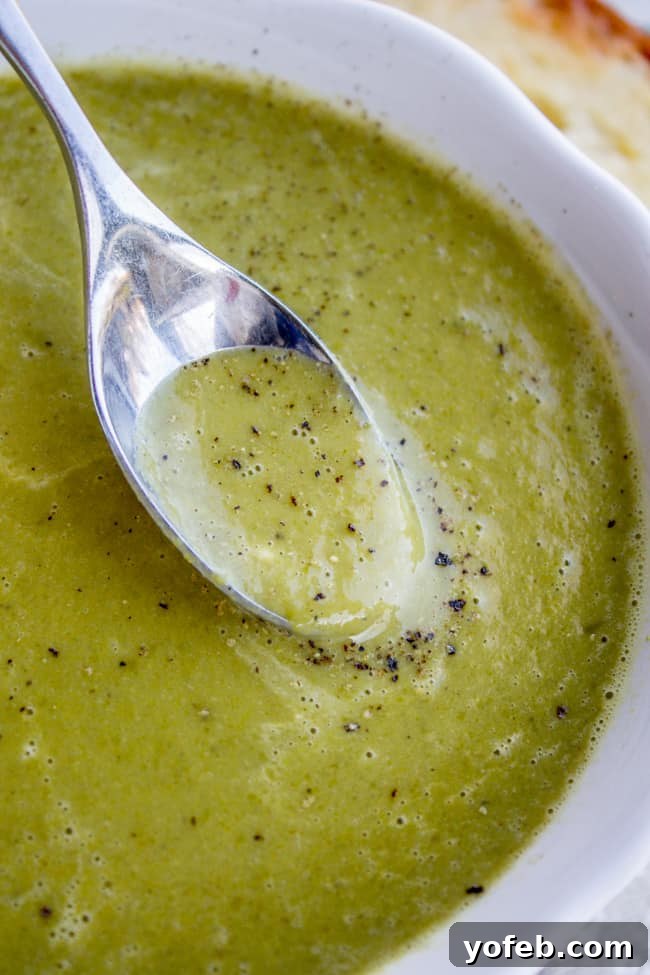 Vibrant 30-Minute Pea Soup 4 A spoon scooping up a generous portion of creamy pea soup, showing off its smooth consistency and inviting texture.