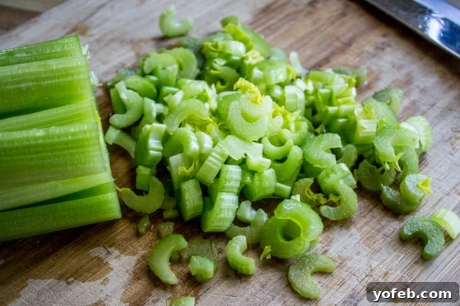 Vibrant 30-Minute Pea Soup 5 Fresh celery stalks being chopped on a rustic wooden cutting board, ready for the soup pot.