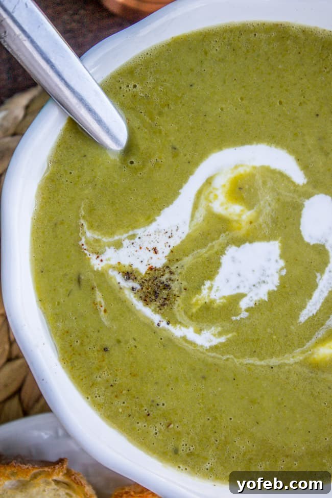 Vibrant 30-Minute Pea Soup 7 A beautifully presented bowl of creamy pea soup, garnished with a swirl of fresh cream and a sprinkle of black pepper, ready to be served.