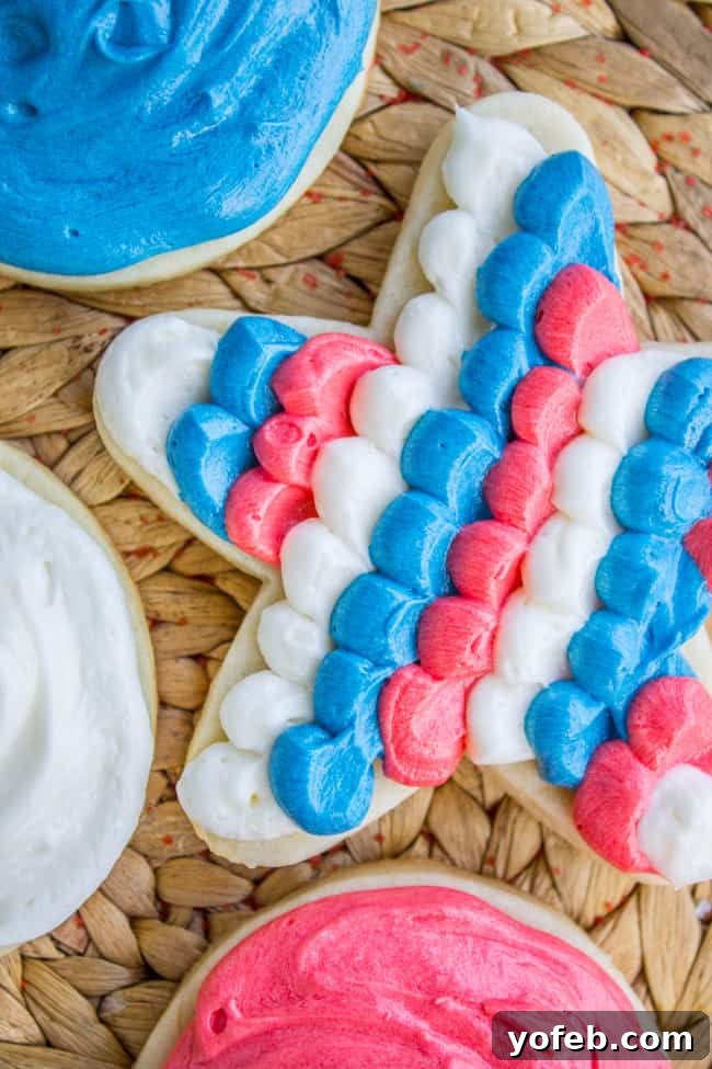 The Softest Sugar Cookies of Your Life from The Food Charlatan. A secret ingredient in this sugar cookies recipe makes these cookies the SOFTEST and most flavorful cookies of your life! And they even hold their shape after baking, so you get exactly what you want instead of sad blob cookies. #sugarcookies #cookies #frosting #soft #recipe #holiday #christmas #easter #halloween #fourthofjuly #stpatricksday #cookies #easy Red, white, and blue-frosted Fourth of July soft sugar cookie.