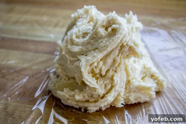 The Softest Sugar Cookies of Your Life from The Food Charlatan. A secret ingredient in this sugar cookies recipe makes these cookies the SOFTEST and most flavorful cookies of your life! And they even hold their shape after baking, so you get exactly what you want instead of sad blob cookies. #sugarcookies #cookies #frosting #soft #recipe #holiday #christmas #easter #halloween #fourthofjuly #stpatricksday #cookies #easy sticky cookie dough, unrolled.