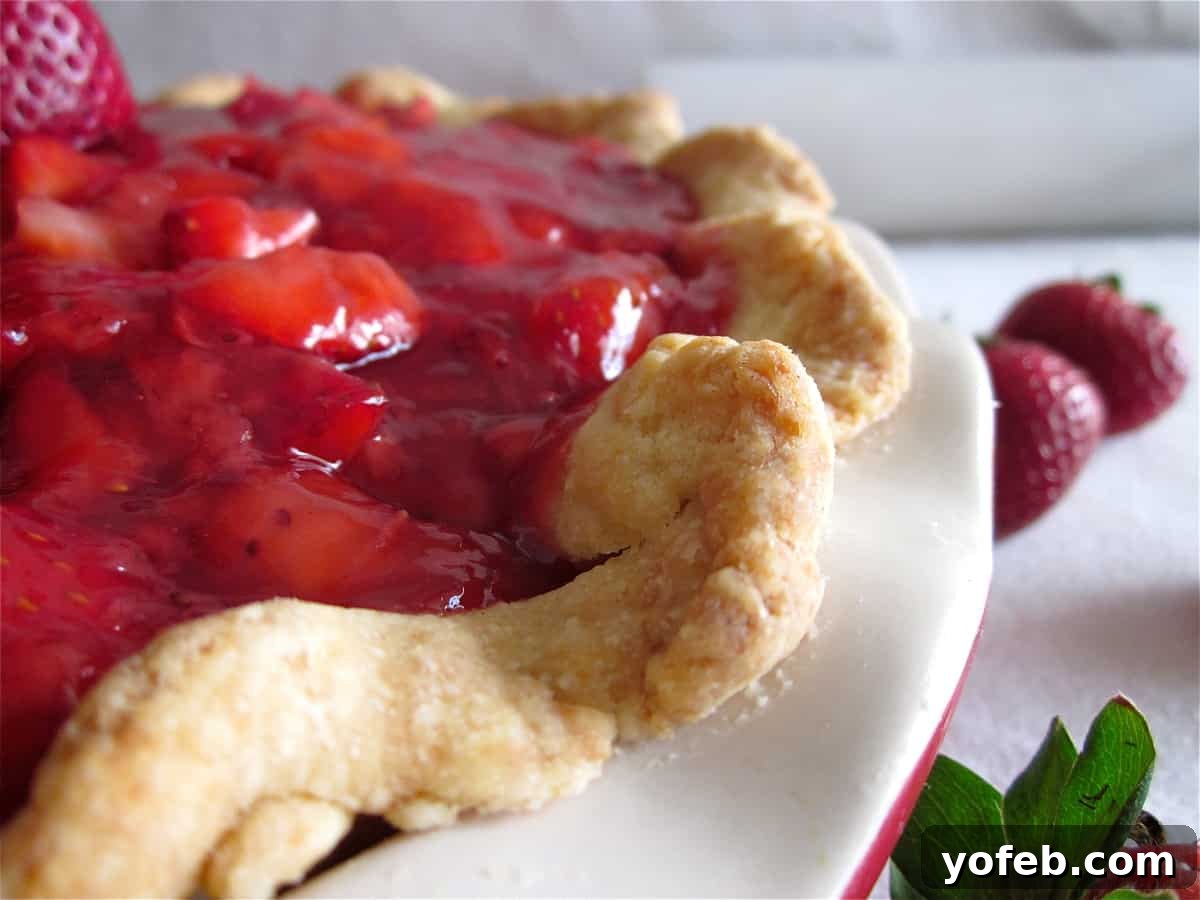Finished Strawberry Glace Pie A close-up shot of a stunning Strawberry Glace Pie, showcasing its vibrant red glaze, fresh strawberry halves, and the visible cream cheese layer beneath.
