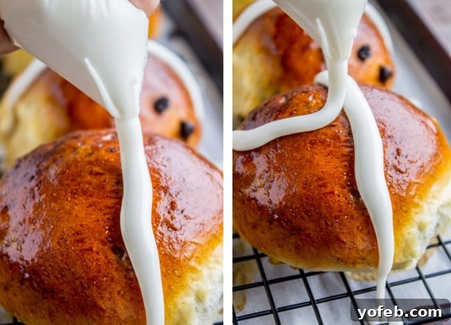 The Best Homemade Hot Cross Buns 12 A clear piping bag applying a white icing cross onto a baked hot cross bun.