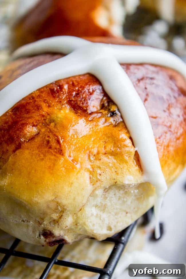 The Best Homemade Hot Cross Buns 14 A close-up shot of a single hot cross bun, beautifully iced and ready to eat.