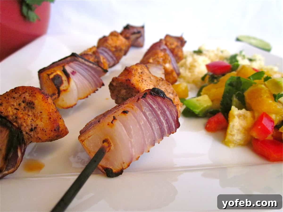 Chicken Kebab Preparation Juicy chicken kebab pieces and bright red onion segments ready for broiling on skewers, showcasing the vibrant marinade.