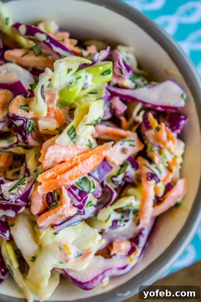 Zesty Lemon Herb Coleslaw 2 A vibrant bowl of fresh lemon herb coleslaw, garnished with chopped green herbs, ready to be served.