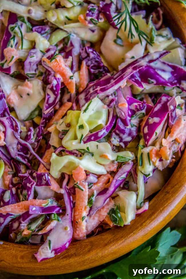 Zesty Lemon Herb Coleslaw 13 A large, inviting bowl of fresh homemade lemon herb coleslaw sits on a table, perfectly mixed and ready to be enjoyed.