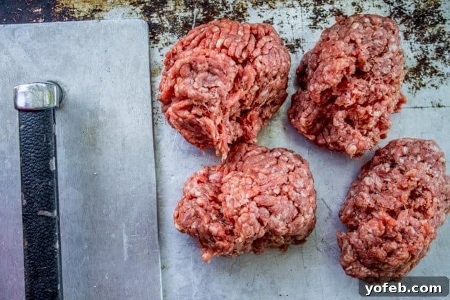 Pre-Smash: Ground Beef on Cast Iron Skillet Uncooked ground beef balls resting on a cast iron skillet, poised for the smashing process.