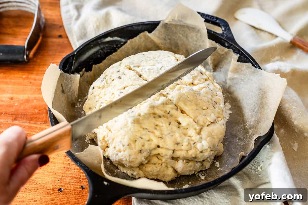 Pure Irish Soda Bread Perfection 14 Slicing divots in the top of Irish soda bread dough before baking with bread knife in cast iron skillet.